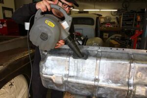 Vintage car fuel tank being inspected for corrosion and deposits